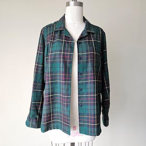 May include: A green, yellow, and red plaid long-sleeved shirt with a button-up front.