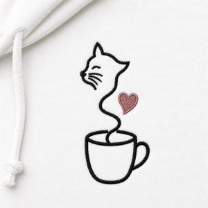 Könnte beinhalten: Ein weißer Kapuzenpullover mit einer Stickerei, die den schwarzen Umriss einer Kaffeetasse zeigt, aus der ein Katzenkopf wie Dampf aufsteigt, ergänzt durch ein kleines, ausgefülltes rosa Herz rechts neben dem Katzenhals und eine weiße Kordel.