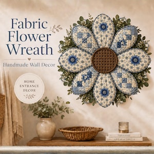 Peut inclure: Une couronne de fleurs en tissu avec des pétales matelassés aux motifs bleus et crème et un centre brun foncé, entourée de feuillage vert. Le texte indique : Fabric Flower Wreath, Handmade Wall Decor, Home Entrance Decor, This is Home, Live Beautifully.