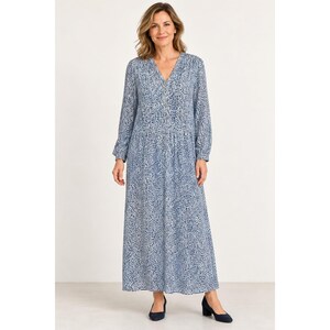 May include: A long-sleeved maxi dress featuring a blue and white abstract pattern. The garment has a V-neckline with a button-down placket, a gathered waist seam, and a loose, flowing skirt that reaches the ankles. The fabric has a consistent print.