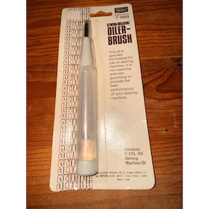 May include: A Kenmore sewing machine oiler-brush in its original packaging. The clear plastic applicator contains 1/3 fl. oz. of sewing machine oil. The white cardboard backing features the text Sewing Machine Oiler-Brush and product details.