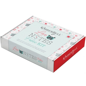 Puede incluir: Una caja cuadrada de kit de tela con fondo blanco y detalles rojos. La caja presenta el texto "Love Notes Fabric Kit" con un gráfico de máquina de escribir. La caja está decorada con corazones y sobres.