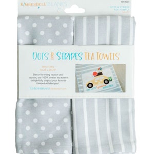 May include: A package of two steel grey tea towels. One towel has white polka dots, and the other has vertical white stripes. The packaging reads "DOTS & STRIPES TEA TOWELS" and "18.25 x 28.25".