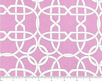 May include: Pink fabric featuring a repeating pattern of white interlocking geometric shapes. The design includes overlapping ovals and rectangular elements, creating a trellis-like effect. The fabric has a textured appearance, and a ruler is visible along the bottom edge.