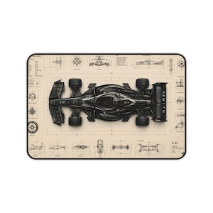 May include: A rectangular desk mat featuring a top-down technical blueprint of a black Formula 1 race car labeled X-01. The design includes detailed mechanical schematics, various component diagrams, and technical annotations on a beige background.