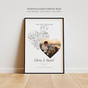 Könnte beinhalten: Ein gerahmter personalisierter Fotokarten-Druck mit dem Text THE DAY WE SAID YES, einer herzförmigen Straßenkarte mit roter Markierung, einem herzförmigen Foto eines Heiratsantrags, den Namen Olivia & Daniel sowie geografischen Koordinaten.