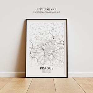 May include: A framed wall art print featuring a black and white city line map of Prague, Czech Republic. The map displays intricate road networks and geographic lines, with the text PRAGUE, CZECH REPUBLIC, and coordinates 50.07 N | 14.43 E.