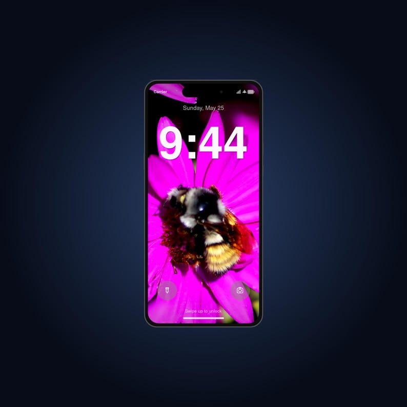 May include: A smartphone displaying a lock screen with a vibrant pink flower and a bumblebee. The screen shows the time 9:44, the date Sunday, May 25, a carrier signal, battery icon, and small icons for a flashlight and camera at the bottom.