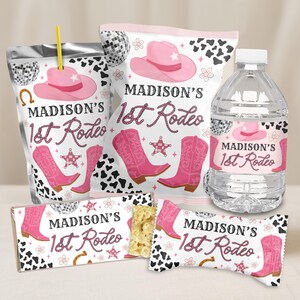 May include: A collection of party favors with a rodeo theme. The items include a juice pouch, a bag of chips, a water bottle, and two candy bar wrappers. Each item features a pink cowboy hat, boots, and the text "MADISON'S 1st Rodeo".