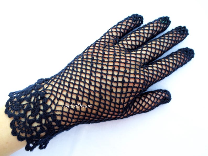 May include: Black crocheted gloves with a delicate lace pattern at the wrist. The gloves are made of a fine mesh material.