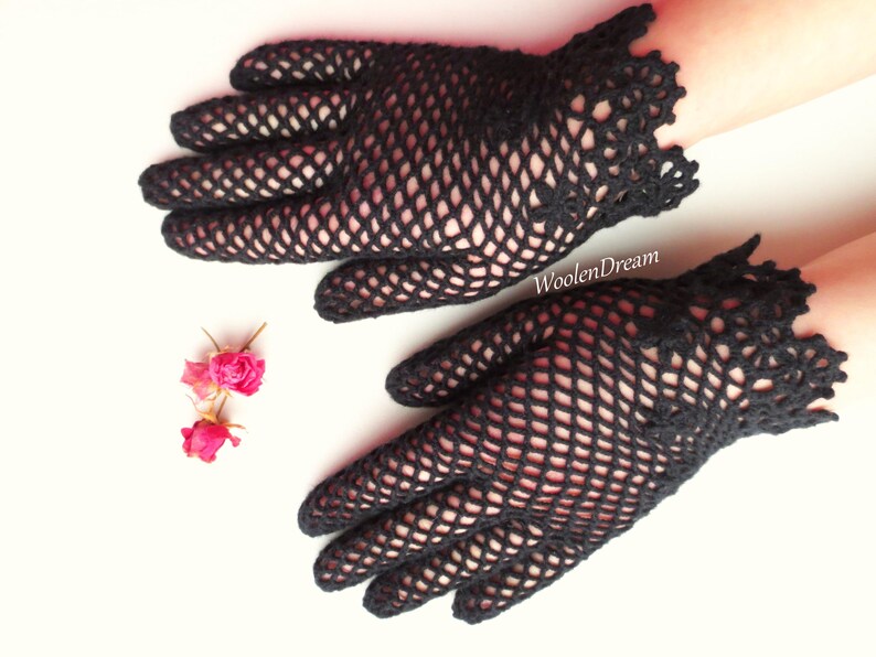 Puede incluir: Un par de guantes de ganchillo negros con un delicado patr&oacute;n de encaje. Los guantes est&aacute;n hechos de una tela fina y de tejido abierto y tienen un estilo ajustado.