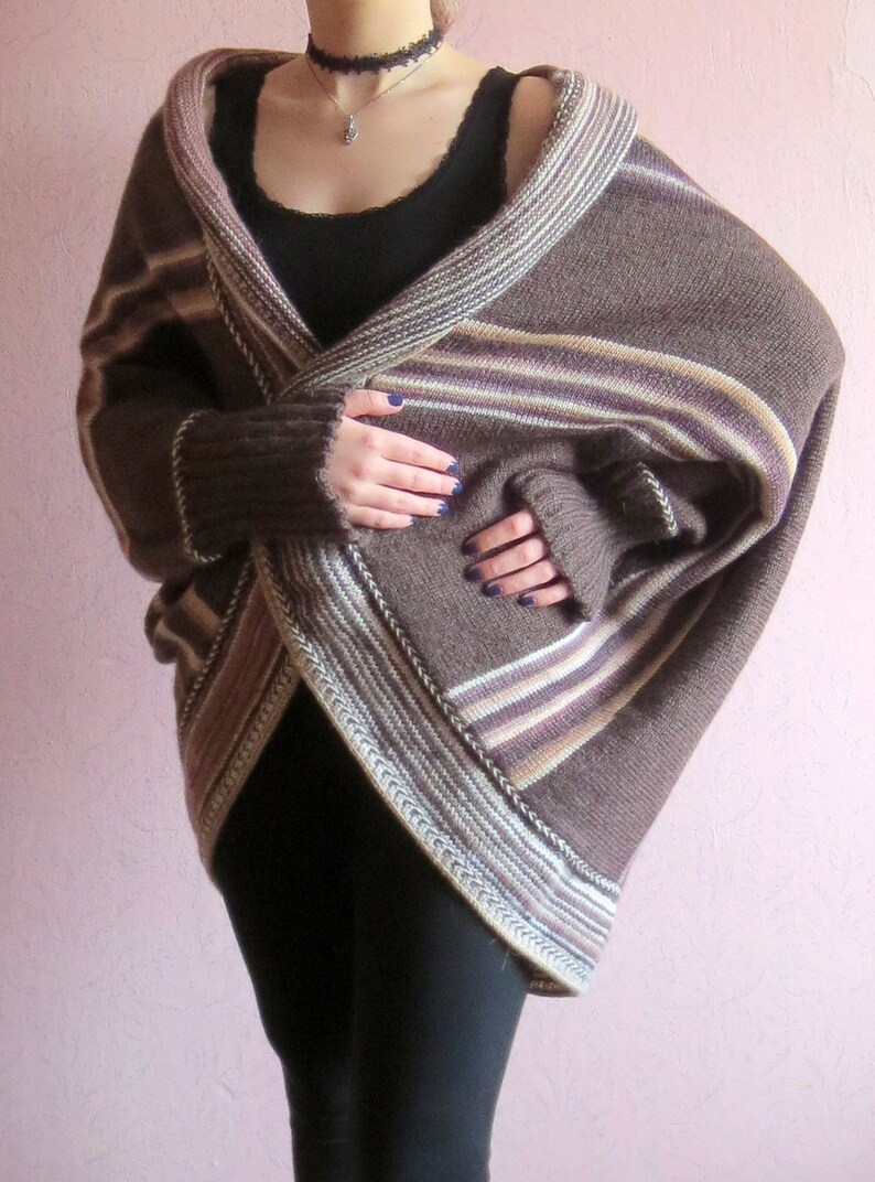 May include: A brown and white striped knit cardigan with a long, flowing design. The cardigan is open at the front and has a V-neck.