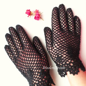 Puede incluir: Un par de guantes de ganchillo negros con un delicado patr&oacute;n de encaje en la mu&ntilde;eca. Los guantes est&aacute;n hechos con un dise&ntilde;o de malla fina.