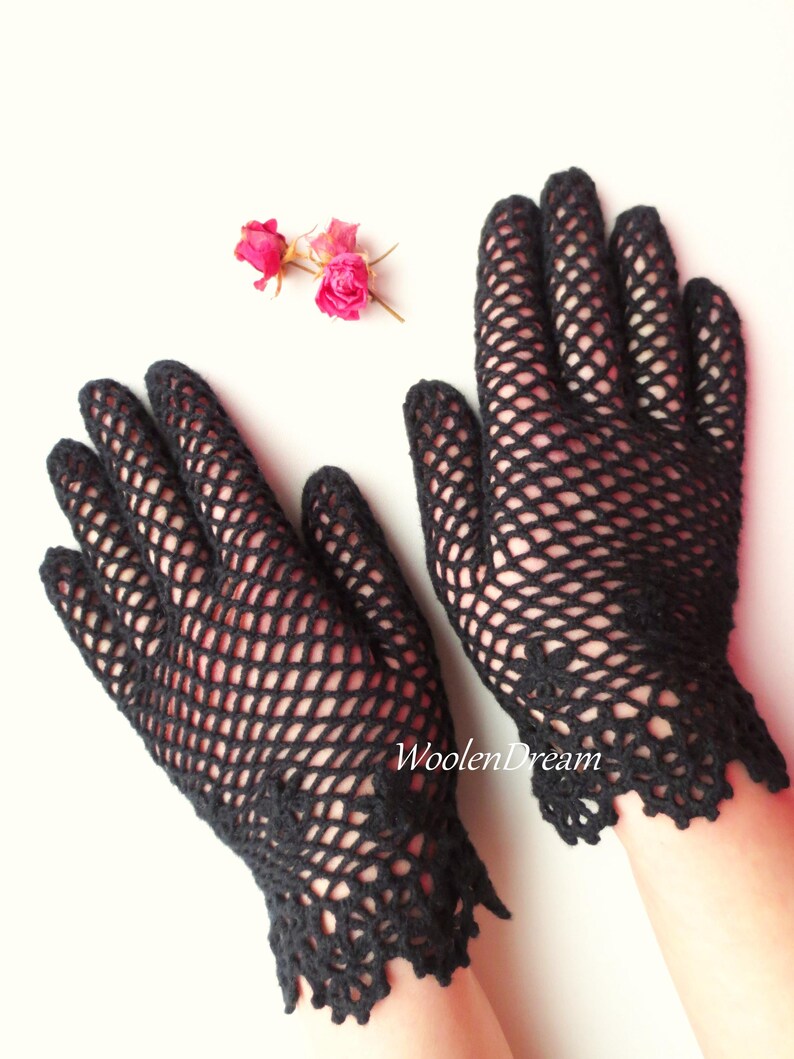 Puede incluir: Un par de guantes de ganchillo negros con un delicado patr&oacute;n de encaje en la mu&ntilde;eca. Los guantes est&aacute;n hechos con un dise&ntilde;o de malla fina.