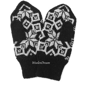 以下が含まれることがあります： 雪の結晶模様の黒と白のニットミトン。ミトンはウール製で、柔らかく温かい肌触りです。