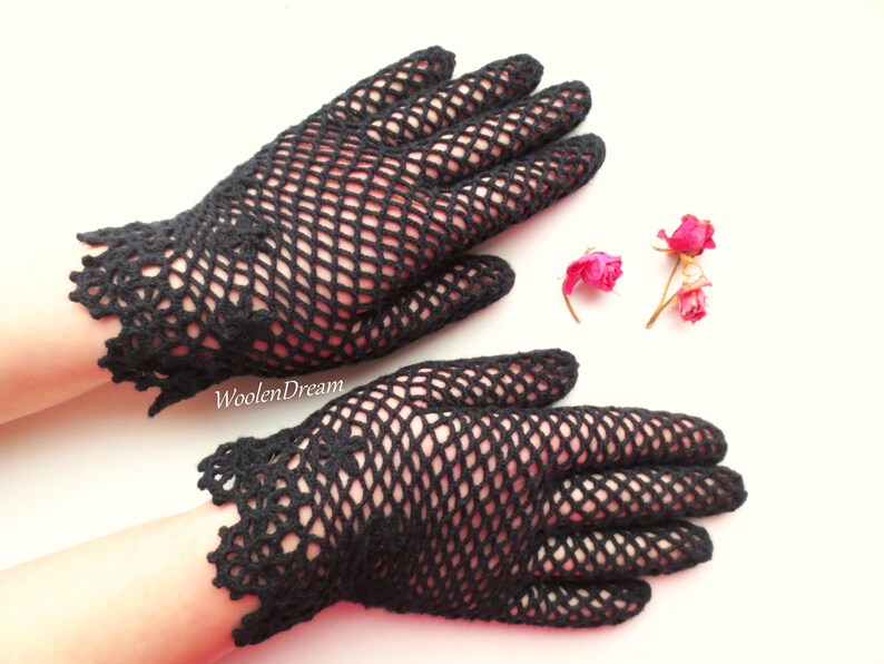 Puede incluir: Un par de guantes de ganchillo negros con un delicado patr&oacute;n de encaje. Los guantes est&aacute;n hechos de un material de malla fina y tienen un estilo ajustado.