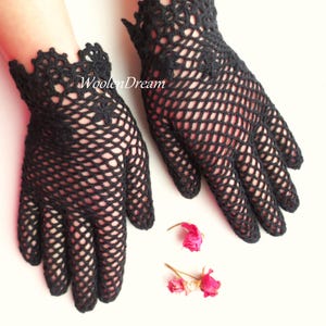 Puede incluir: Un par de guantes de ganchillo negros con un delicado patr&oacute;n de encaje. Los guantes son sin dedos y tienen un borde festoneado.