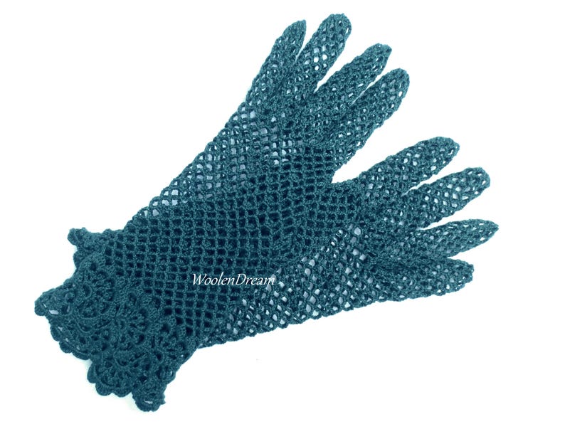 May include: A pair of teal blue crocheted gloves with a lacy design at the wrist. The gloves are made of a fine, open-weave yarn.