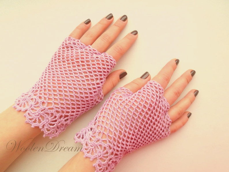 May include: A pair of pink crocheted fingerless gloves with a delicate lace pattern at the wrist.
