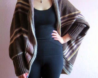 May include: A brown and white striped cardigan with long sleeves and a draped front. The cardigan is made of a soft, knitted fabric.