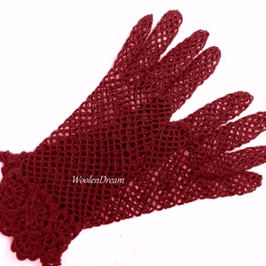 May include: A pair of burgundy crocheted gloves with a delicate lace pattern. The gloves are made with a fine yarn and have a soft, comfortable feel.