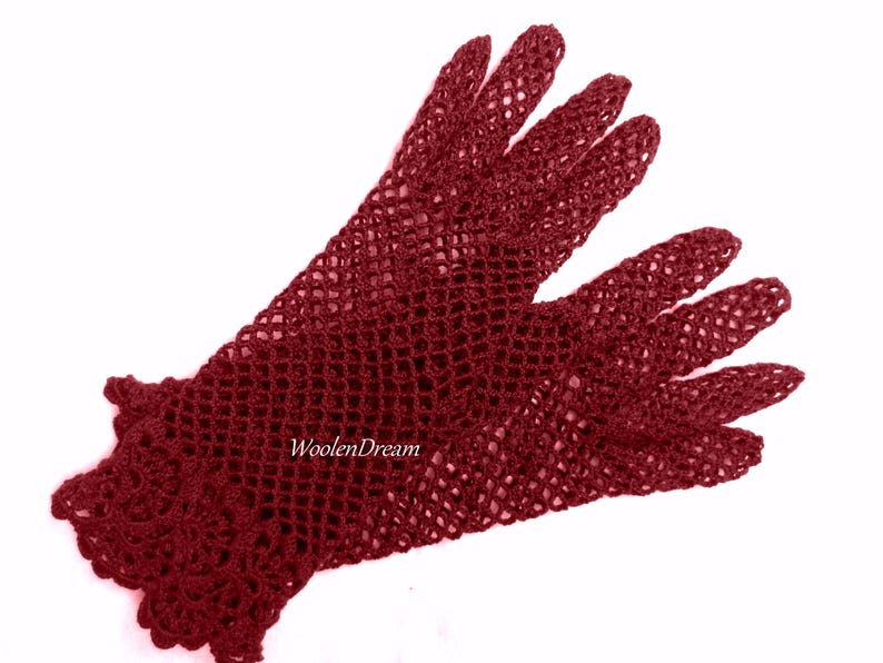 May include: A pair of burgundy crocheted gloves with a delicate lace pattern. The gloves are made with a fine yarn and have a soft, comfortable feel.
