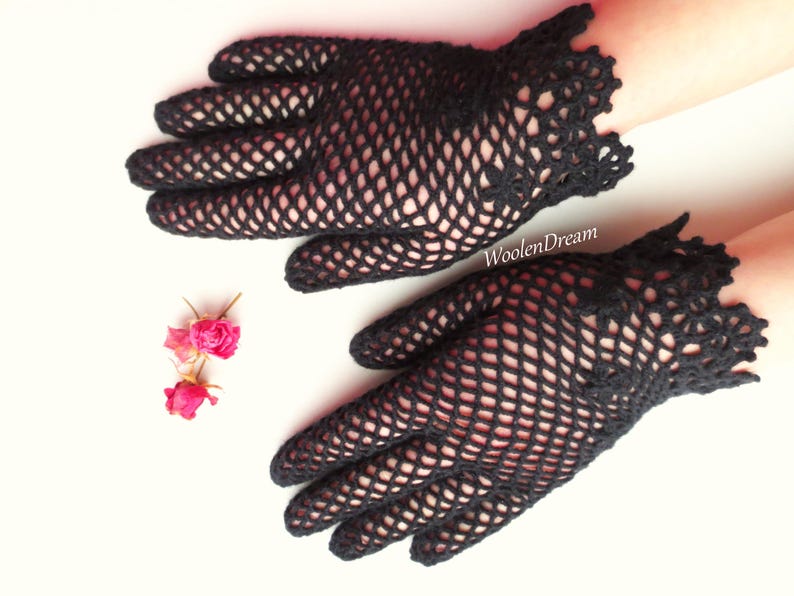 Puede incluir: Un par de guantes de ganchillo negros con un delicado patr&oacute;n de encaje. Los guantes est&aacute;n hechos de una tela fina y de tejido abierto y tienen un estilo ajustado.