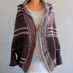 May include: A brown and white striped knitted cardigan with a shawl collar and a wooden button closure. The cardigan has a relaxed fit and is made of a soft, comfortable material.