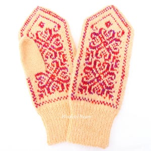May include: A pair of knitted mittens with a floral pattern in shades of pink, red, and purple on a light yellow background.