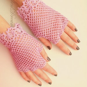 May include: A pair of pink crocheted fingerless gloves with a delicate lace pattern at the wrist.