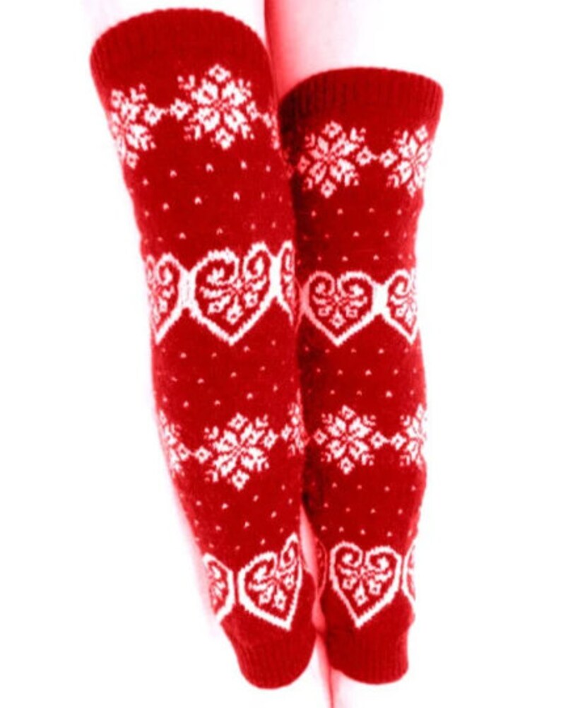May include: Red knit leg warmers with white snowflake and heart patterns. These knee-high leg warmers are designed with a festive winter theme, perfect for adding a touch of warmth and style to any outfit.