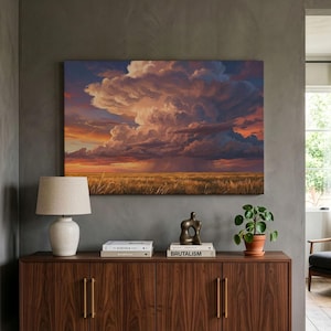 May include: A rectangular canvas wall art print depicting a dramatic sunset over a vast golden field with a large, towering cumulonimbus cloud formation illuminated by orange, purple, and deep blue light, featuring visible rain showers.
