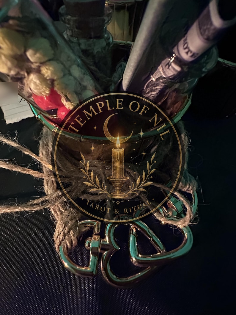 May include: A glass container filled with dried flowers and a rolled paper note, wrapped in natural jute twine. The container features a circular logo with the text TEMPLE OF NIL TAROT & RITUAL, depicting a crescent moon and a lit candle on a stand.