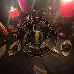 May include: A collection of lit candles in red, pink, and black, arranged with scattered dried leaves and small dark circular tokens. A circular logo featuring a candle, crescent moon, and the text Temple of Nil Tarot & Ritual is centred.