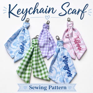 May include: Five fabric keychain scarves with metal lobster clasps. Two feature blue floral patterns with embroidered names, one is green gingham, one is purple gingham, and one is pink floral with an embroidered name. Text reads Keychain Scarf.
