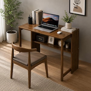 May include: A rectangular wooden desk with a dark brown finish featuring a lower storage shelf, paired with a matching wooden chair with a gray upholstered seat. The desk holds a laptop, a white mouse, books, and a small potted plant.