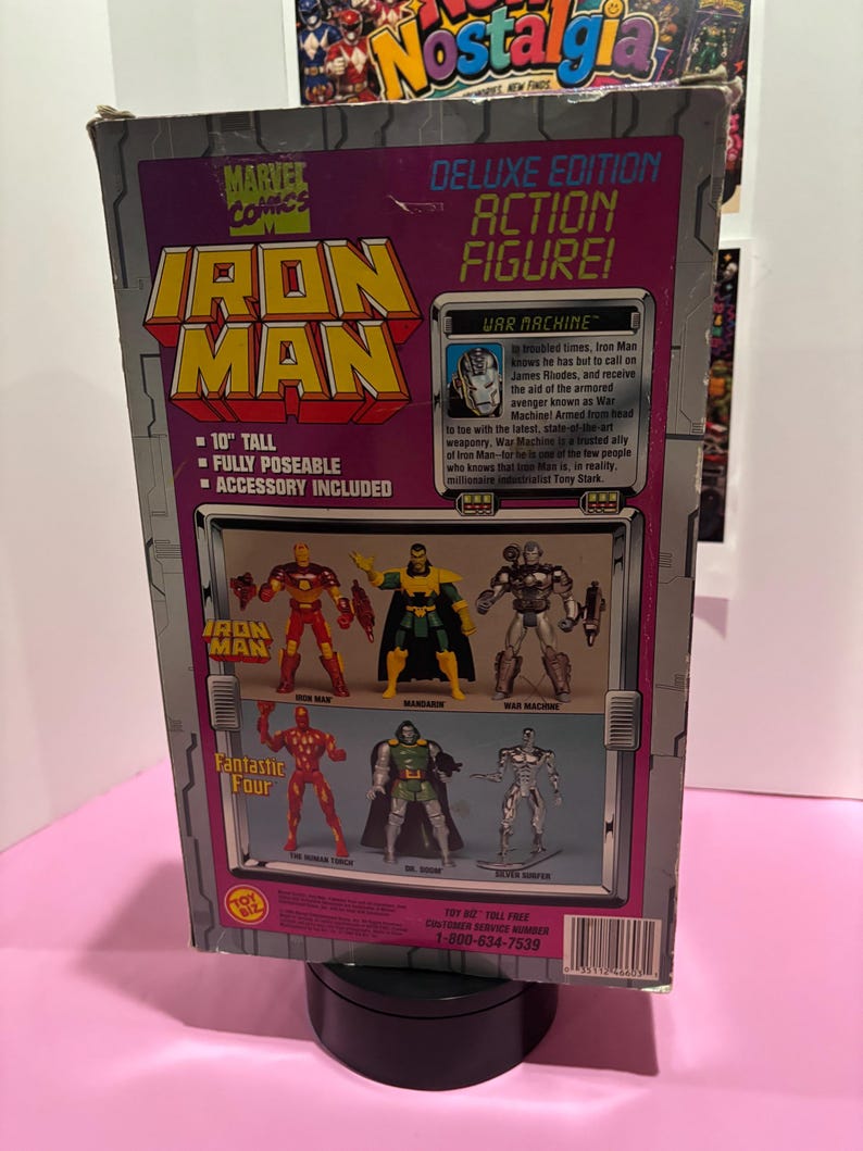 May include: Deluxe Edition Iron Man action figure box. The box is gray and purple with the Marvel Comics logo. The box is 10 inches tall, fully poseable, and includes accessories. The box features images of Iron Man, Mandarin, War Machine, Human Torch, Dr. Doom, and Silver Surfer.