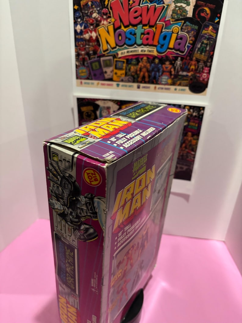 May include: A vintage Iron Man action figure box. The box is purple and features the Iron Man logo in yellow and red. The box also includes the text "10" tall, fully poseable, and accessory included."