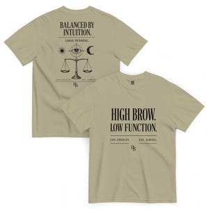 Puede incluir: Una camiseta de color verde oliva claro mostrada por delante y por detrás. El frente presenta el texto negro HIGH BROW. LOW FUNCTION. LOS ANGELES EST. ALWAYS. La parte posterior muestra BALANCED BY INTUITION. LOGIC PENDING. con un gráfico de un ojo y una balanza.