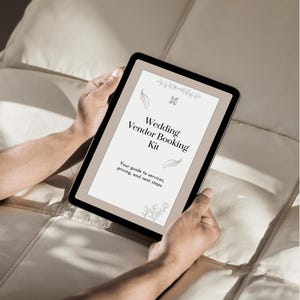 K&ouml;nnte beinhalten: Ein digitales Tablet zeigt ein Dokument mit dem Titel Wedding Vendor Booking Kit und dem Untertitel Your guide to services, pricing, and next steps. Der Bildschirm enth&auml;lt botanische Strichzeichnungen und den Text 30+ PAGES DIGITAL AND PRINTABLE.