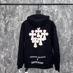 K&ouml;nnte beinhalten: Schwarzer Kapuzenpullover mit wei&szlig;em Kreuzmuster auf dem R&uuml;cken. Der Text "CHROME hearts" ist unter dem Kreuzmuster aufgedruckt. Der Pullover hat eine Kapuze mit Kordelzug und eine K&auml;ngurutasche.