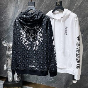 May include: Two hooded sweatshirts hanging on a rack. One is black with a white pattern and text, the other is white with black text on the sleeve. The word "HEARTS" is visible on the white sweatshirt.