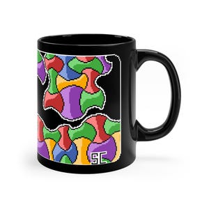 Puede incluir: Taza de cerámica negra con un diseño pixelado colorido de formas abstractas en rojo, verde, morado, amarillo y azul. La taza tiene un borde blanco alrededor del diseño y las iniciales "SC" en la esquina inferior derecha.
