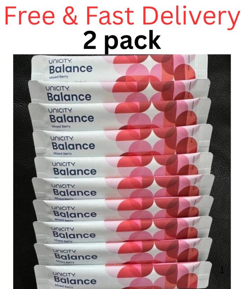 Pode incluir: Um pacote de dois sach&ecirc;s de suplemento alimentar Unicity Balance Mixed Berry. Cada sach&ecirc; retangular branco apresenta o logotipo Unicity Balance em texto azul escuro e um padr&atilde;o de c&iacute;rculos rosa e vermelhos sobrepostos no lado direito.