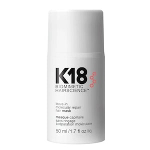 May include: A white cylindrical bottle of K18 Biomimetic Hairscience leave-in molecular repair hair mask. The label features black text, a red molecular graphic, and states 50 ml/1.7 fl oz liq. The container has a matching white cap.