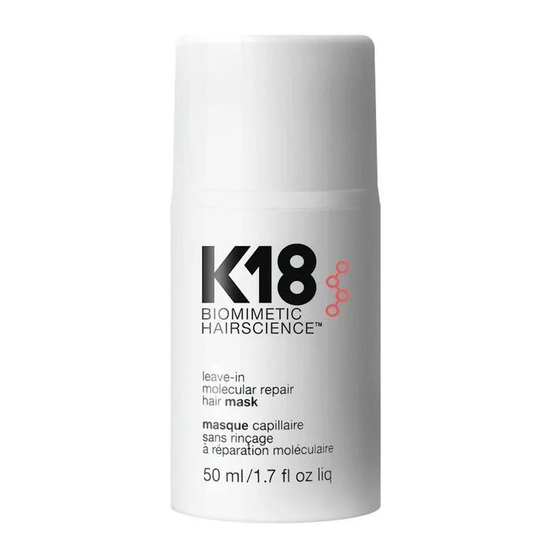 May include: A white cylindrical bottle of K18 Biomimetic Hairscience leave-in molecular repair hair mask. The label features black text, a red molecular graphic, and states 50 ml/1.7 fl oz liq. The container has a matching white cap.