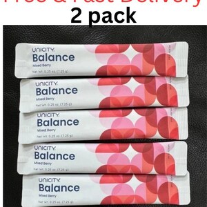 Pode incluir: Cinco saquetas de suplemento Unicity Balance Mixed Berry, cada uma com um peso l&iacute;quido de 7,25 g. A embalagem apresenta um padr&atilde;o geom&eacute;trico de c&iacute;rculos vermelhos e cor-de-rosa sobrepostos, com o nome da marca e sabor em texto azul.