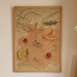 May include: A framed rectangular wall art print featuring a surreal illustration of tiny figures swimming in a spilled pink liquid from a tipped wine glass, surrounded by floating citrus slices, cherries, and a sprig of green rosemary.