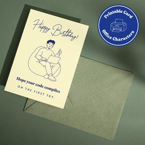 Könnte beinhalten: Eine cremefarbene Grußkarte mit einer dunkelblauen Strichzeichnung einer Person, die in einem Sitzsack sitzt, einen Laptop benutzt und den Daumen hochhält. Der Text lautet Happy Birthday! Hope your code compiles ON THE FIRST TRY. Inklusive Umschlag.