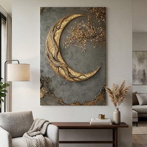 May include: A rectangular wall art piece featuring a large, textured gold crescent moon with intricate filigree patterns. The background is a dark, mottled gray with gold accents. A delicate, glowing tree branch extends from the moon's curve.